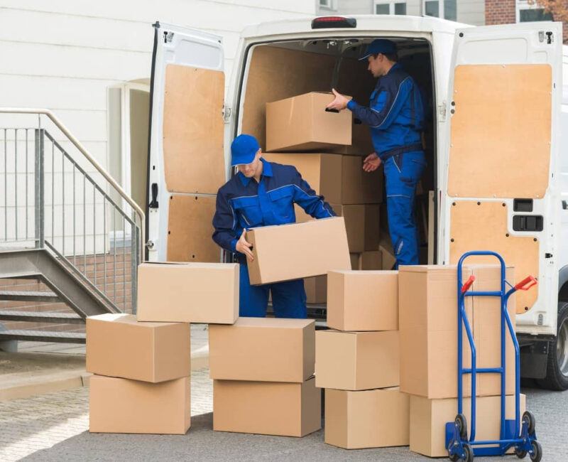 Professional international movers carefully packing and securing household items for a seamless relocation.